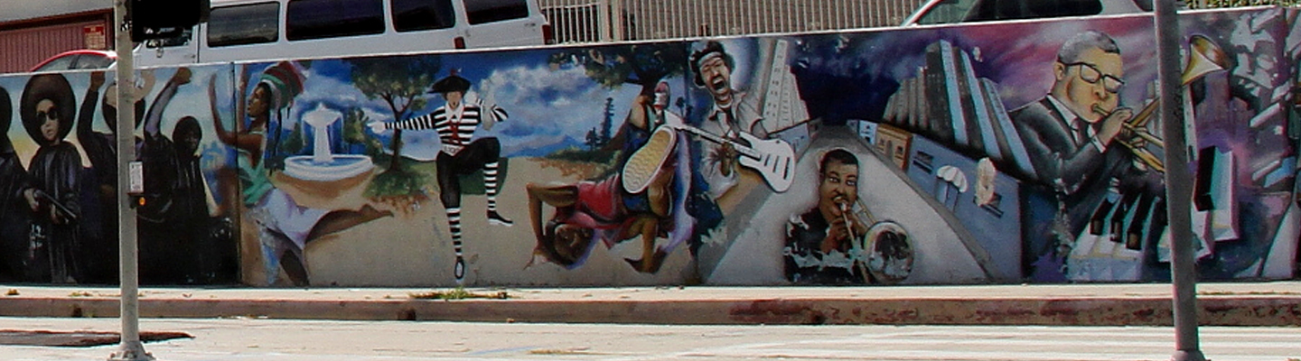 A partial photograph of the “Our Might Contribution” or Crenshaw Wall. There are musicians, dancers, and protesters in the mural.